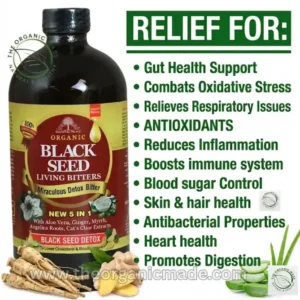 A marketing photograph featuring a large amber glass bottle of BLACK SEED DETOX with a black cap. The front label is detailed, featuring red and white text on a black and gold background, prominently displaying "Miraculous Detox Bitter" and "NEW 5 IN 1" with specific listed ingredients including Aloe Vera, Ginger, Myrrh, Angelica Roots, and Cat's Claw Extracts. Illustrations of black seeds, a white flower, and halved aloe vera are on the label. Below the bottle, there are raw roots (ginseng or angelica) on the left, sliced ginger and black seeds in the center, and fresh aloe vera stalks and gel slices on the right. In the upper left and lower right corners are "THE ORGANIC MADE, NATURAL & HEALTHY" logos. To the right of the bottle, on a white background, large green text reads "RELIEF FOR:" followed by a vertical, bulleted list in green text: "Gut Health Support", "Combats Oxidative Stress", "Relieves Respiratory Issues", "ANTIOXIDANTS", "Reduces Inflammation", "Boosts immune system", "Blood sugar Control", "Skin & hair health", "Antibacterial Properties", "Heart health", "Promotes Digestion". The website address "www.theorganicmade.com" is visible in white across the lower portion of the image. The entire composition is set against a clean white background, presenting a balanced and informative layout.