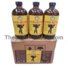Natural Men Tonic 16oz - Wholesale 2 A photograph showing three large amber glass bottles of 'Natural Men Tonic, Extra Strong,' positioned side-by-side on top of a single, closed cardboard shipping box. Each bottle features a detailed yellow and black label with the brand logo and the product name. The shipping box has a larger version of the bottle label affixed to its front panel, displaying ingredient and nutritional information. The scene is illuminated in a clean, professional studio style, with all elements sharp and centered. A watermark with the text 'Theorganicmade.com' overlays the image.