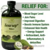 A marketing photograph featuring a single, large amber glass bottle of 'MANDINGO SOURSOP+ BITTERS' with a black cap. The front label on the bottle is visible, featuring green text that reads 'ALL NATURAL REMEDY FOR COLON CLEANSING' and 'Net Wt. 16 oz.' Below the text is an illustration of two green soursop fruits. To the left of the bottle, in the upper corner, is 'THE ORGANIC MADE, NATURAL & HEALTHY' logo. To the right of the bottle, on a white background, large green text reads 'RELIEF FOR:' followed by a vertical bulleted list in green text: 'Blood Sugar Level', 'Join Pains', 'Improved Digestion', 'Boosts Immune System', 'Enhanced Skin Health', 'Energy Support', 'Antioxidant, Anti-inflammatory & detoxifies'. Below the list, a grouped illustration of a halved soursop fruit revealing its white flesh and seeds, alongside a pile of dried herbs and seeds. The website address 'www.theorganicmade.com' is in white text across the bottom.