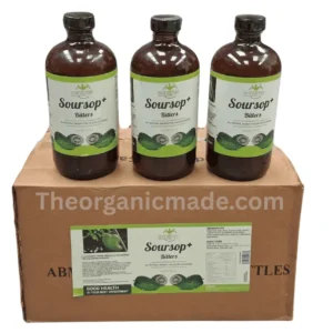 A photograph showing three amber glass bottles of Mandingo Soursop plus Bitters sitting side-by-side on top of a single, closed brown cardboard shipping box. Each bottle and the shipping box feature detailed labels with green and white branding, product text 'SOURSOP+ BITTERS', 'ALL NATURAL REMEDY FOR COLON CLEANSING', and images of green soursop fruit. A watermark 'Theorganicmade.com' is visible