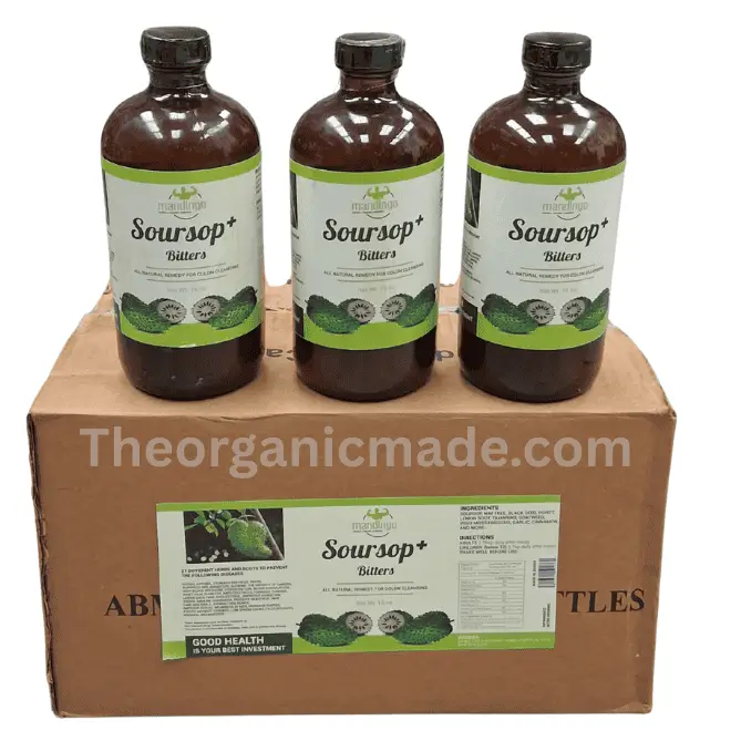 Mandingo Soursop Plus Bitters 16oz (Wholesale) 1 A photograph showing three amber glass bottles of Mandingo Soursop plus Bitters sitting side-by-side on top of a single, closed brown cardboard shipping box. Each bottle and the shipping box feature detailed labels with green and white branding, product text 'SOURSOP+ BITTERS', 'ALL NATURAL REMEDY FOR COLON CLEANSING', and images of green soursop fruit. A watermark 'Theorganicmade.com' is visible