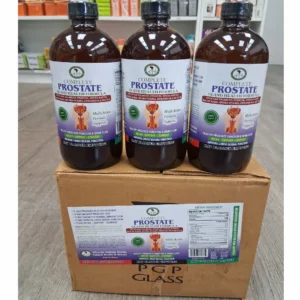 A Clean photograph showing three large, amber glass bottles of "Complete Prostate Gland Health Formula" with black caps, positioned side-by-side on top of a sealed cardboard box. Each bottle features a detailed blue and white label with the product name and key health claims. The cardboard box also has a larger, full label affixed to the front, displaying the supplement facts panel and product description. The image is taken from a three-quarter view, slightly elevated. A large, transparent watermark text "Theorganicmade.com" overlays the lower half of the image. The bottles are filled with a liquid supplement. The packaging looks secure and professional.