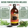 A glass bottle of Black Seed Bitters is centered on a light wood surface, flanked by two informational boxes. The left box, labeled 'KEY BENEFITS', lists bullet points like 'Boost Immunity', 'Supports Digestion', 'Colon Cleansing', and 'Detoxification Properties'. The right box, labeled 'NATURAL INGREDIENTS', lists 'Black Seed', 'Flax Seeds', 'Moringa Leaf', 'Aloe Vera', and 'Ginger'. Raw ingredients—a bunch of fresh mint leaves, a whole ginger root, and several sliced ginger pieces—are arranged around the base of the bottle. Red arrows point from above the boxes toward the bottle. At the very top, large, bold green text reads 'EMPOWER YOUR HEALTH NATURALLY'. Below this, the red text reads 'BLACK SEED BITTERS: EXTRA STRONG DETOX BEVERAGE'.